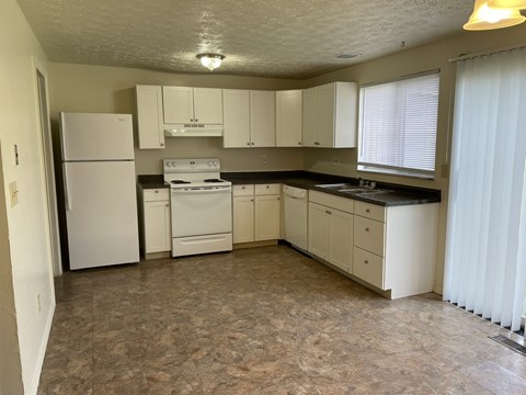 A kitchen with white appliances and cabinets.
