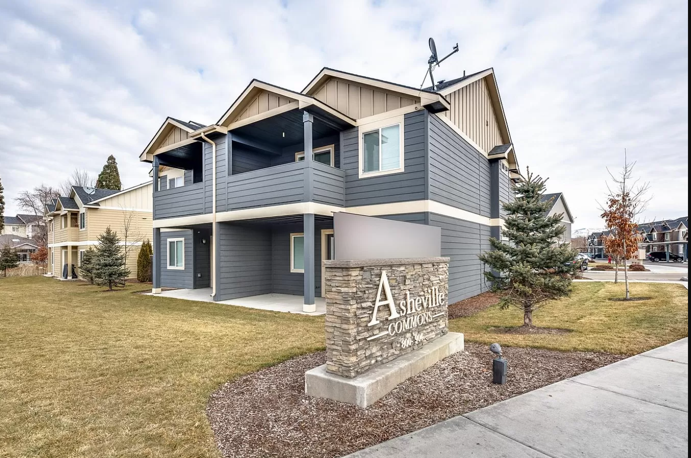 the front of a house with a stone sign in front of it