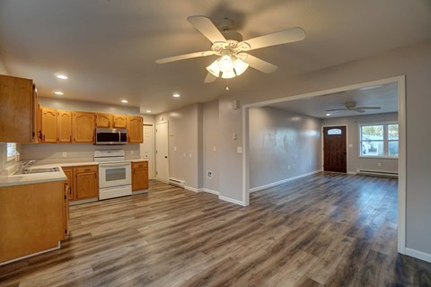 A kitchen with wooden cabinets and a ceiling fan.