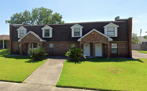 a red brick house with white windows and a lawn