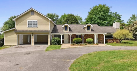 A two-story house with a garage and a driveway.