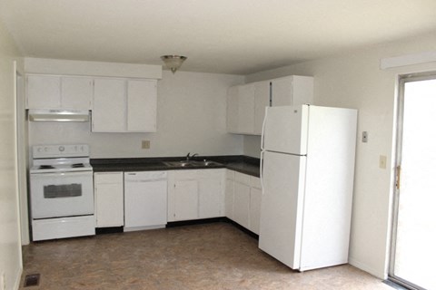 A kitchen with white appliances and cabinets.