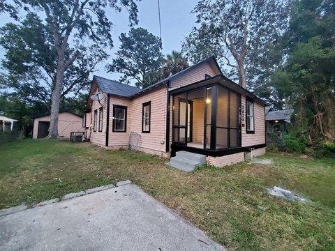 the front of a small house with a yard and a driveway