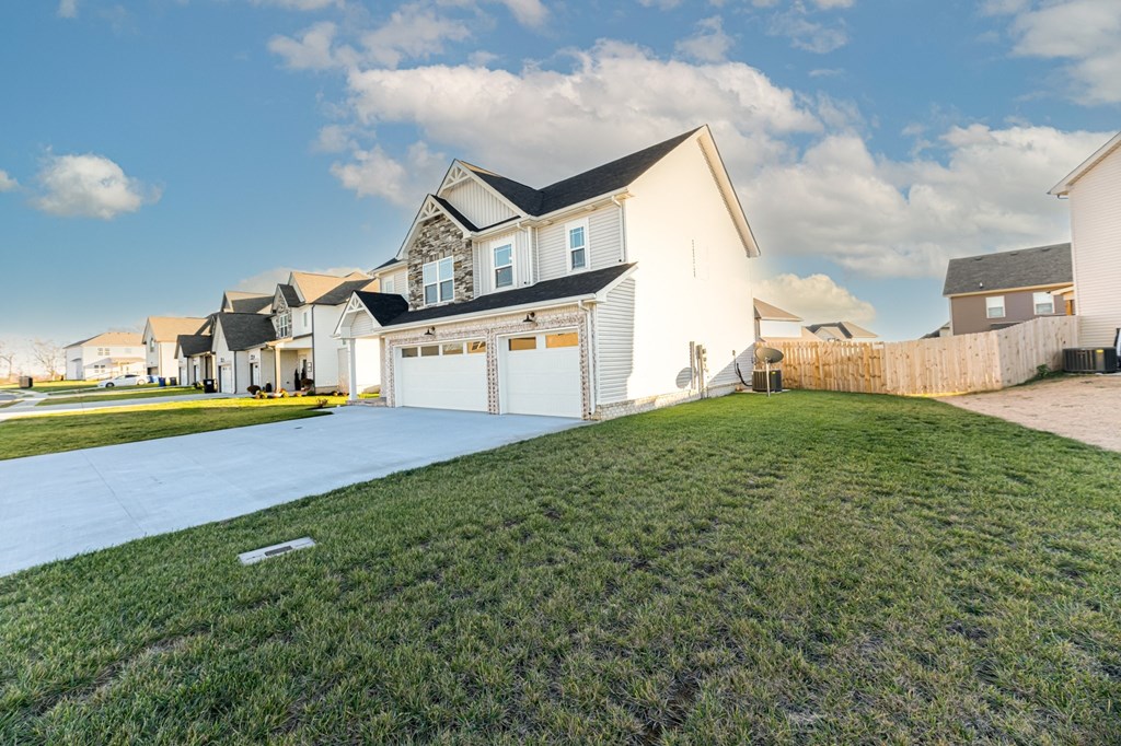 a house with a driveway and lawn in front of it
