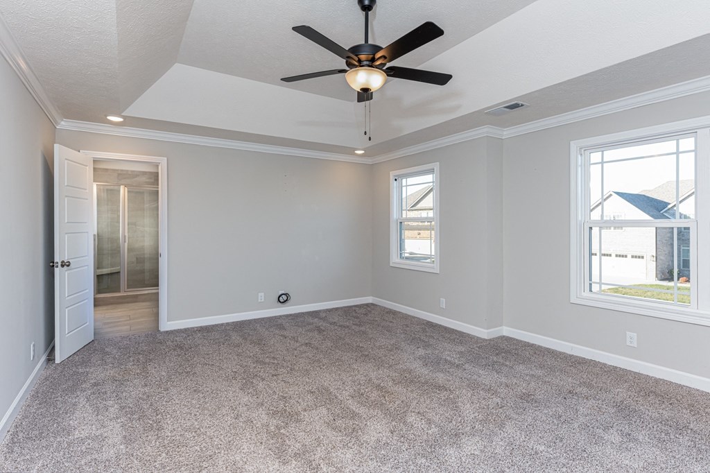an empty living room with a ceiling fan and a window