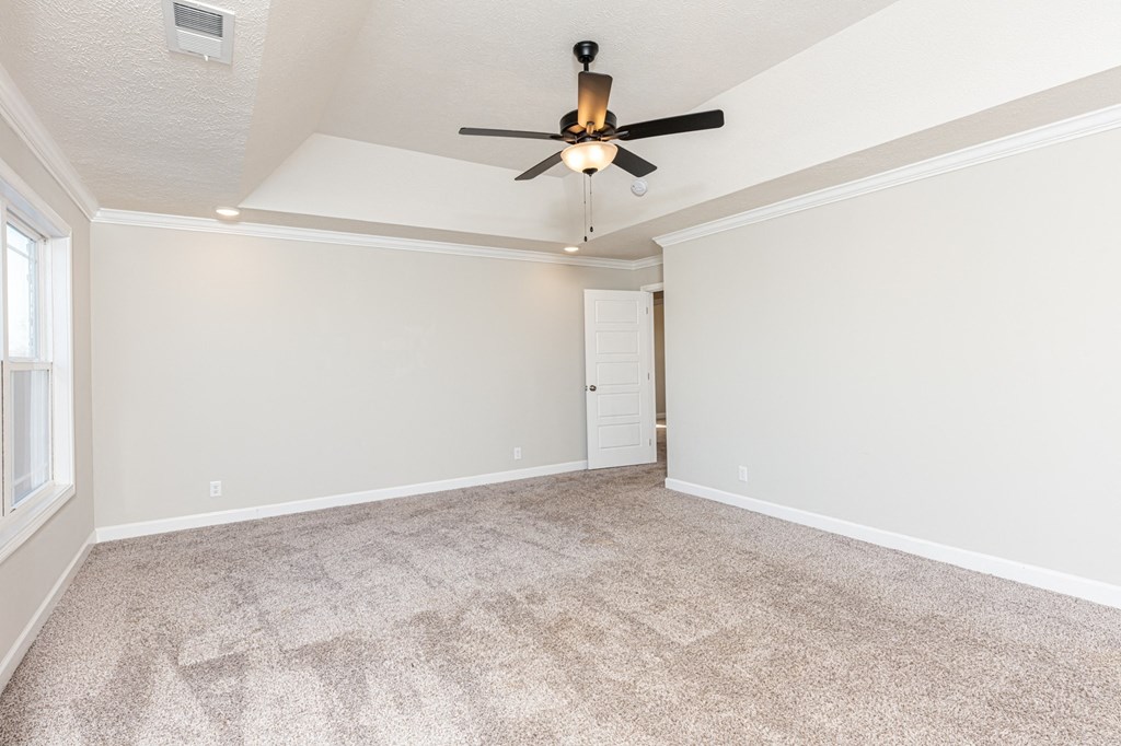 an empty living room with a ceiling fan