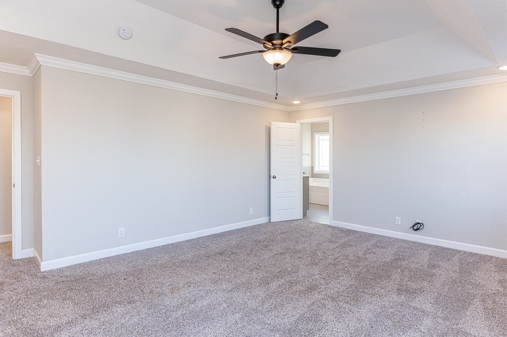 an empty living room with a ceiling fan