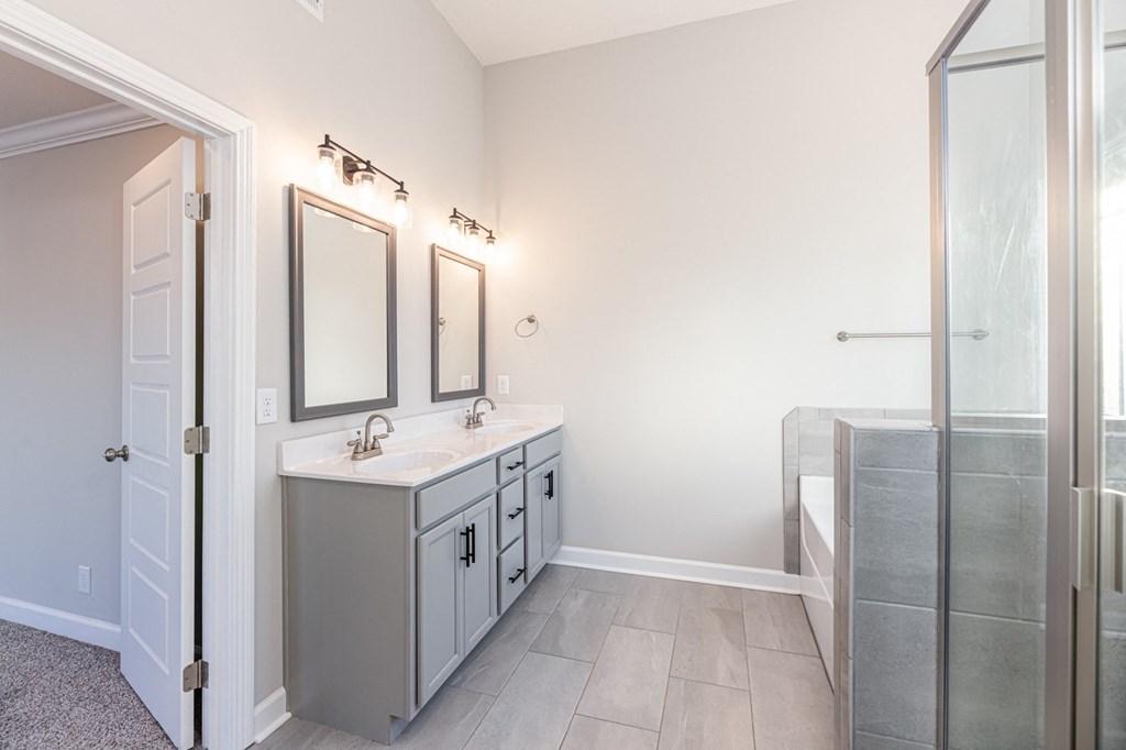 a bathroom with a sink and a shower and a mirror