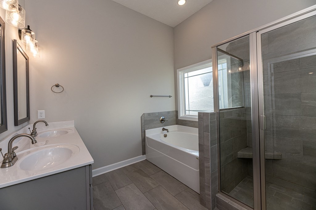 a bathroom with a tub and a sink and a shower