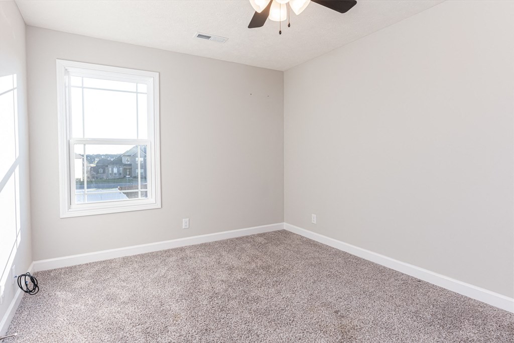 an empty room with carpet and a window