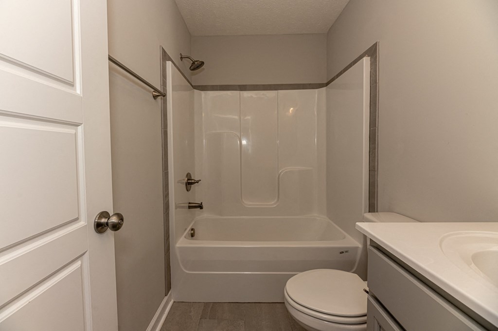 a bathroom with a shower and a toilet and a sink