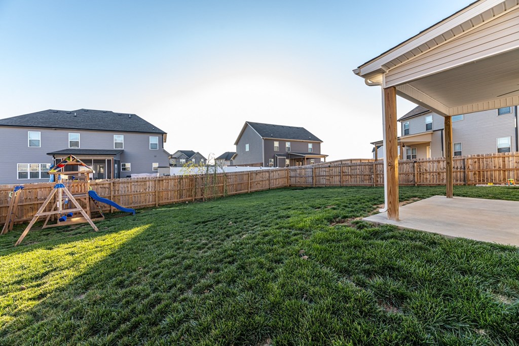 a backyard with a swing set and a fence