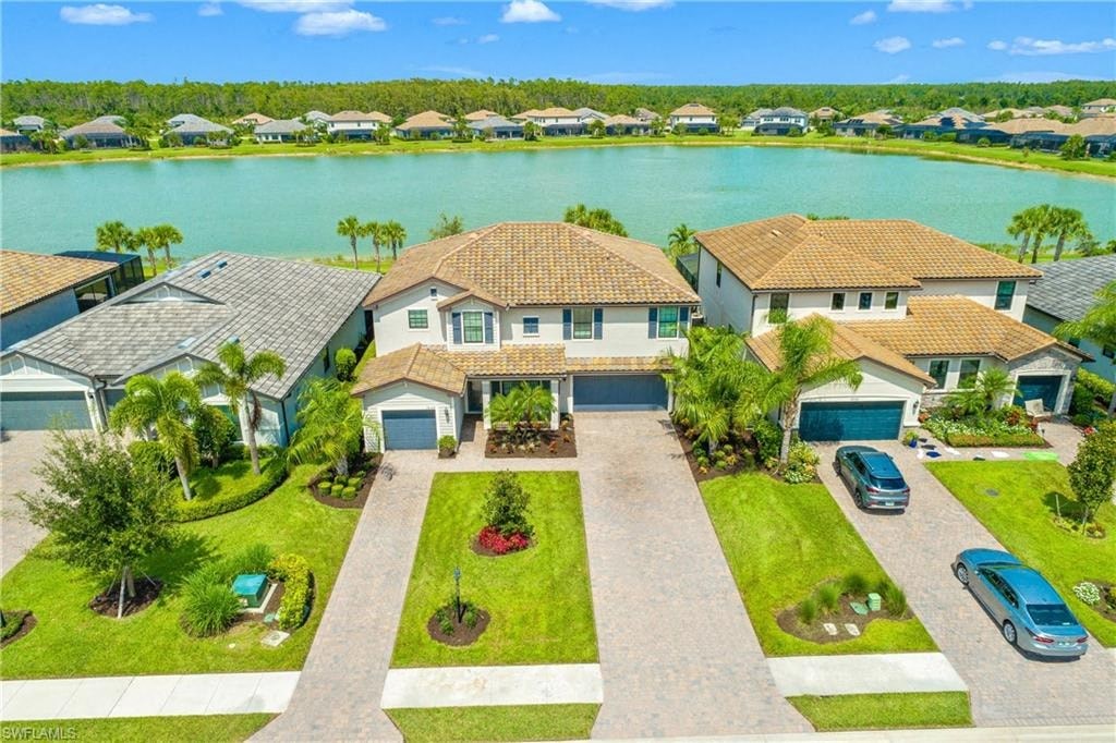 an aerial view of a house with a lake in the background