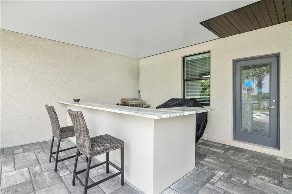a kitchen with a bar and two stools
