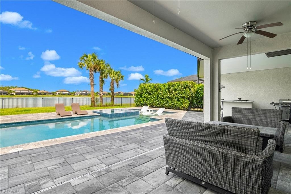 a patio with a pool and chairs and a ceiling fan
