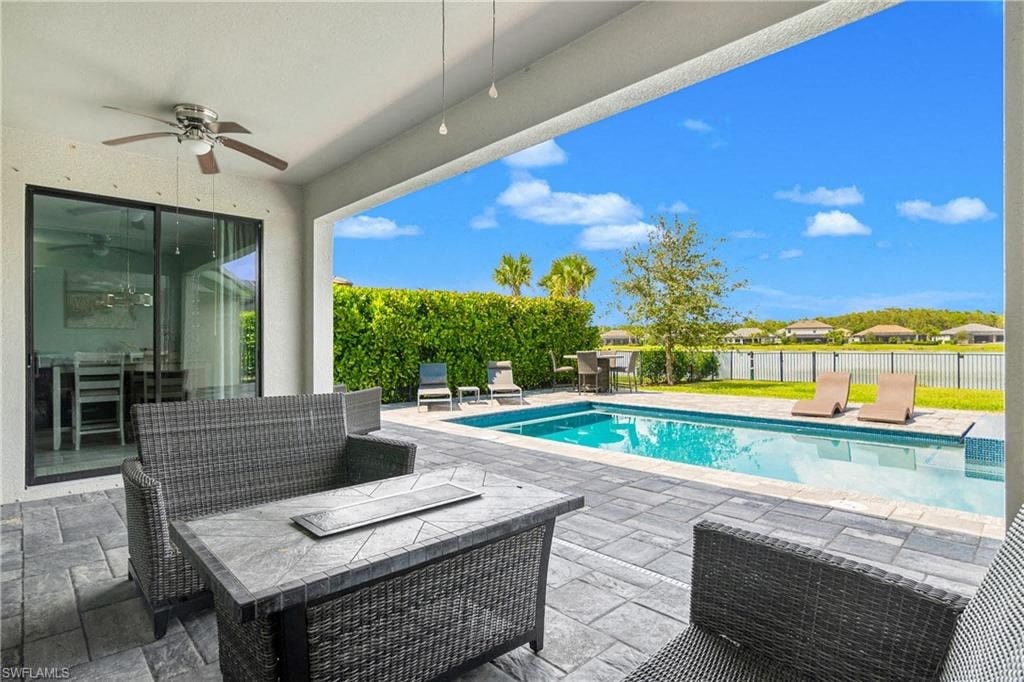 a backyard with a pool and a patio with chairs and a table