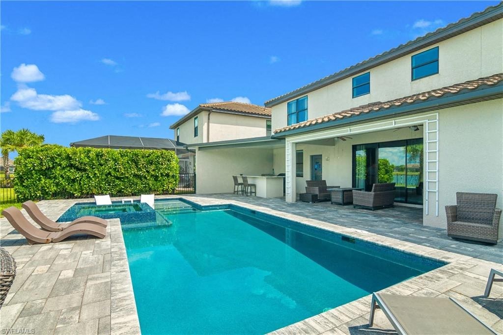 a swimming pool and patio in front of a house