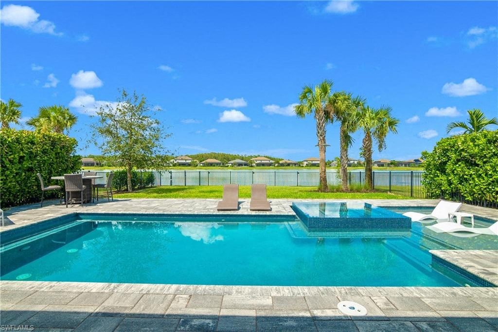 a swimming pool with palm trees and a lake in the background