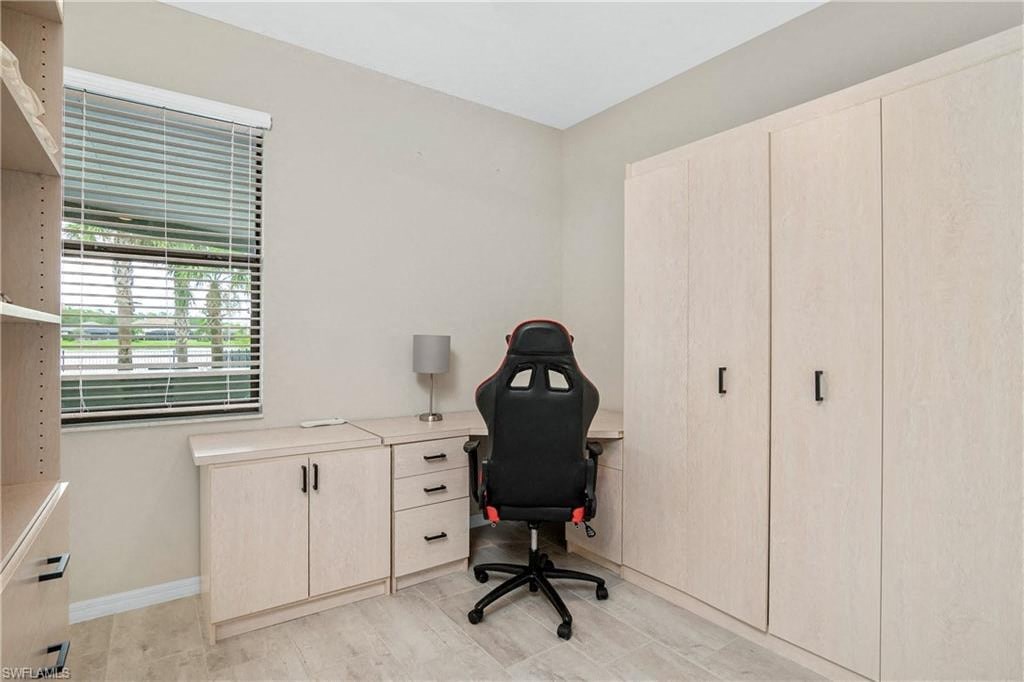 an office with a desk and a chair and a window