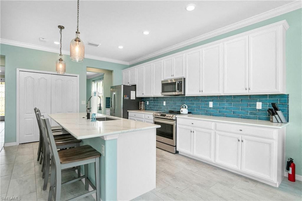 a kitchen with white cabinets and a table and chairs