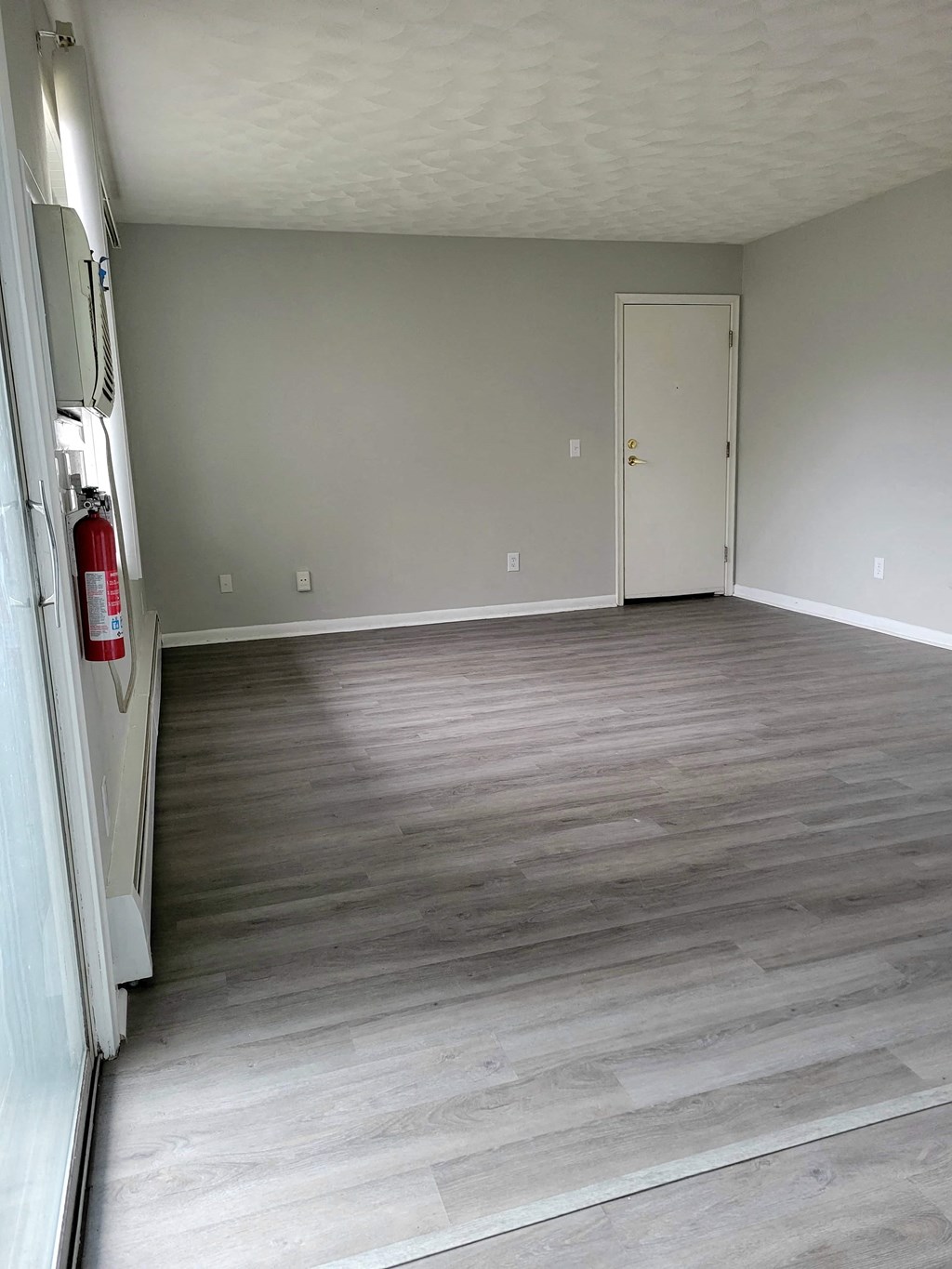 an empty room with wood floors and a door