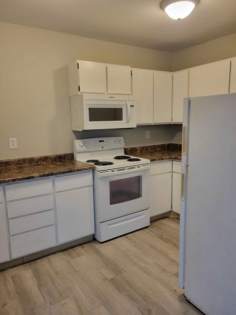 a kitchen with white appliances and white cabinets