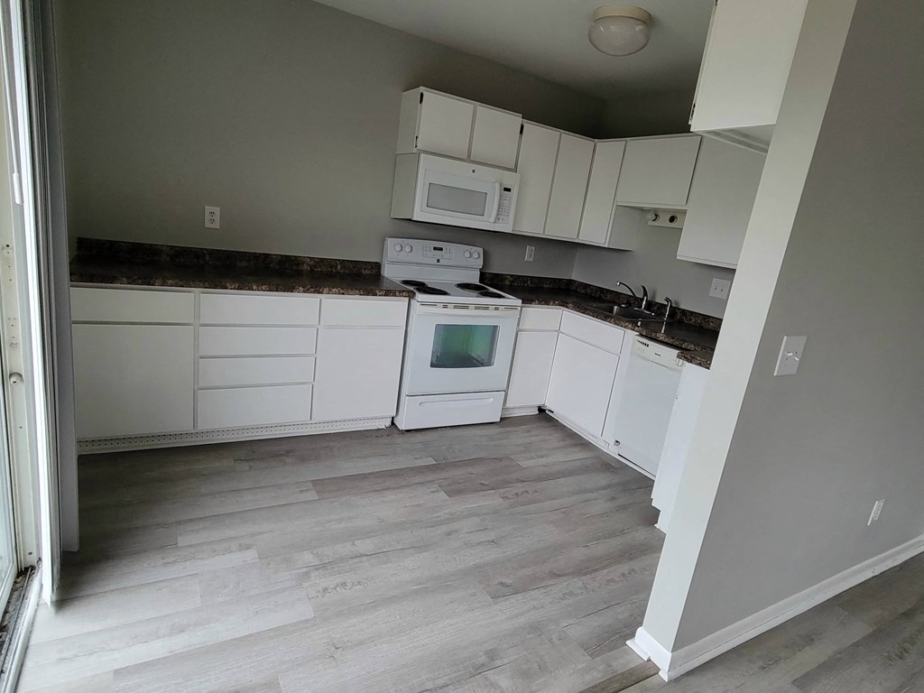 a kitchen with white cabinets and a stove and a microwave