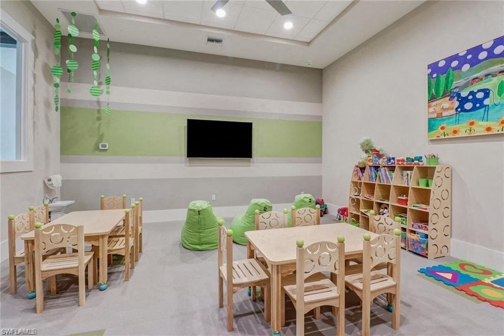a preschool room with tables and chairs and a tv