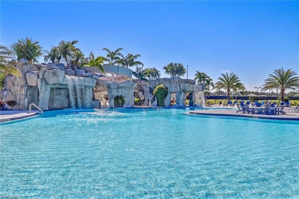 a large pool with a waterfall and palm trees