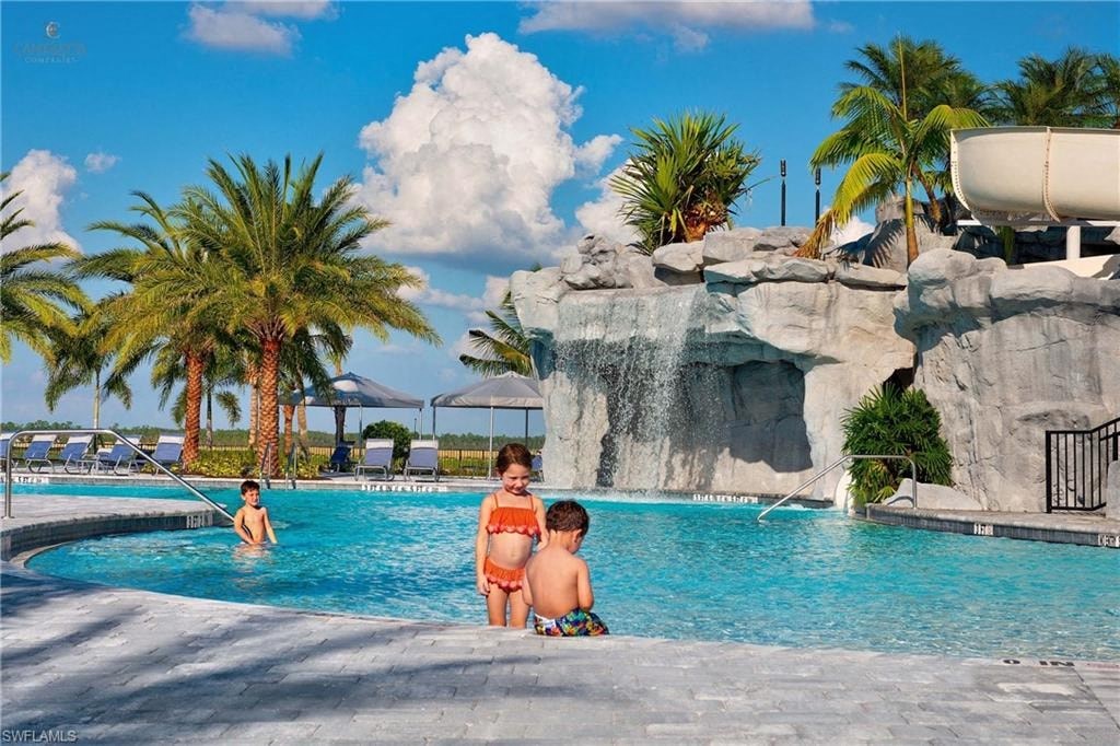 three children in a swimming pool at a resort