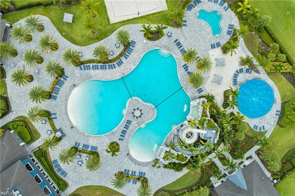 an aerial view of a swimming pool with umbrellas and palm trees