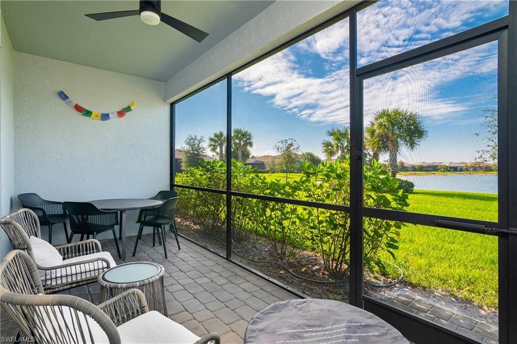 a balcony with a view of a lake and a patio with chairs and tables