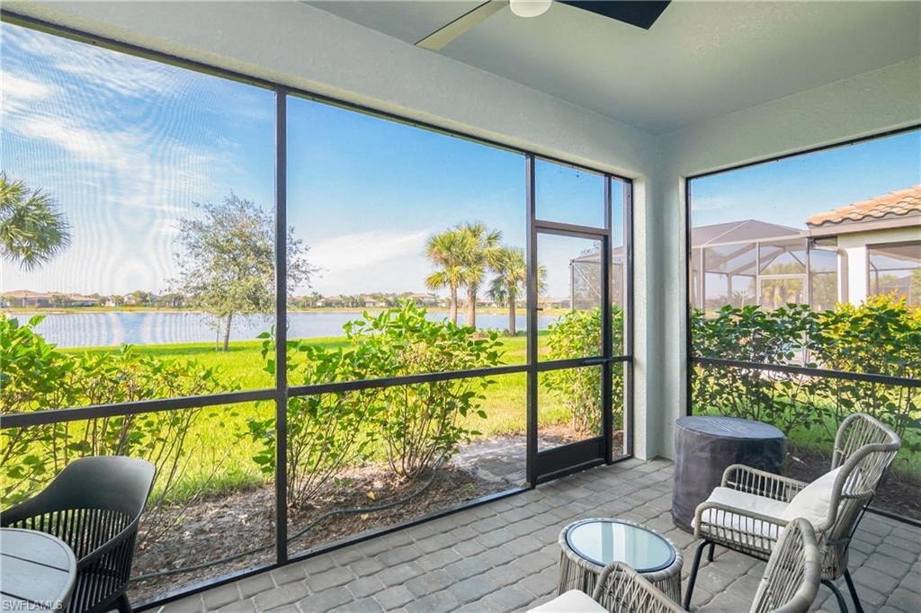 a balcony with a view of a lake and a patio with tables and chairs
