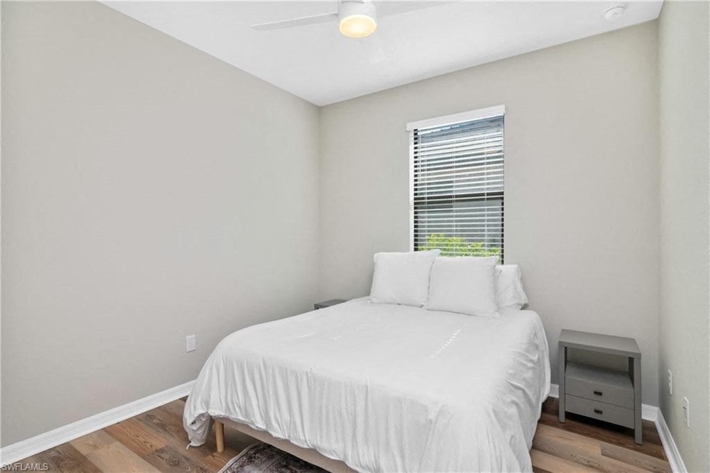 an empty bedroom with a white bed and a window
