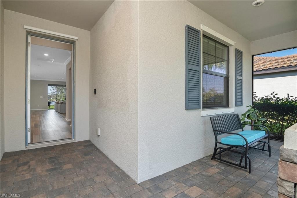 a patio with a chair and a door to a hallway