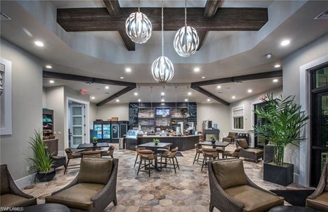 the lobby of a restaurant with tables and chairs and a bar