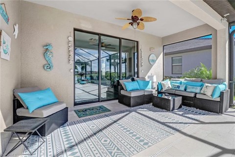 a covered patio with furniture and a ceiling fan