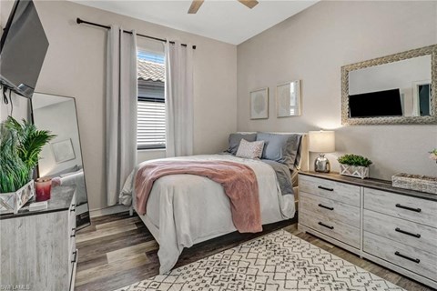 a bedroom with a bed and a mirror on the wall