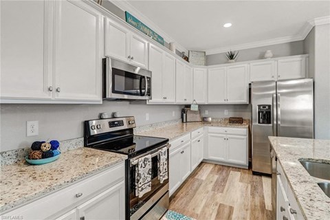 a kitchen with white cabinets and stainless steel appliances