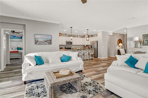 a living room and kitchen with couches and a table