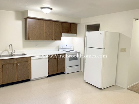a kitchen with white appliances and wooden cabinets