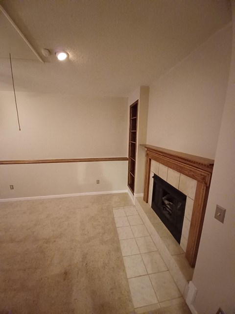 a living room with a fireplace and a tiled floor
