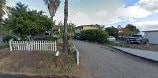 A road with a white fence and a sign on the side.
