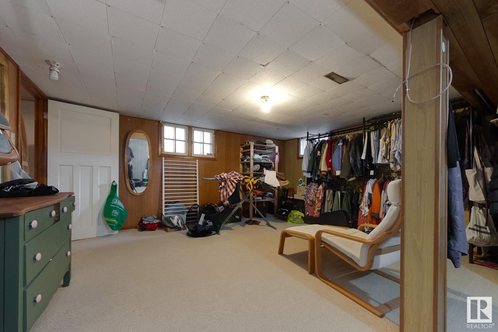 a room with a closet and a dresser and a chair in it