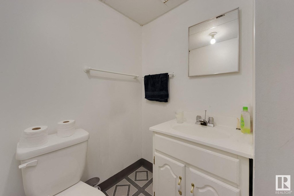 a white bathroom with a toilet and a sink