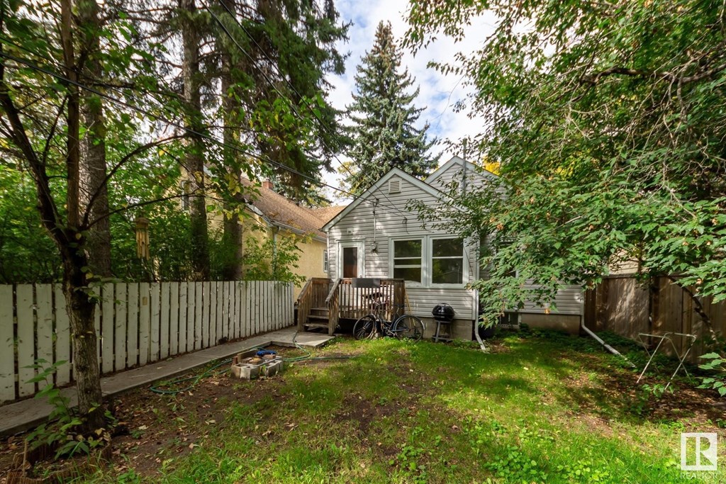 a small white house with a yard and a white fence