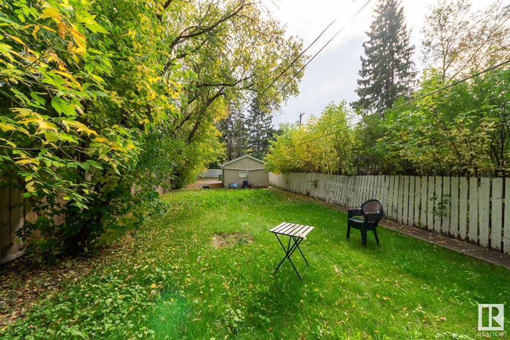 a backyard with a table and a chair in the grass