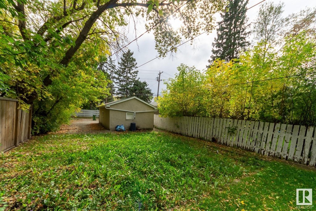 a backyard with a white fence and a small house