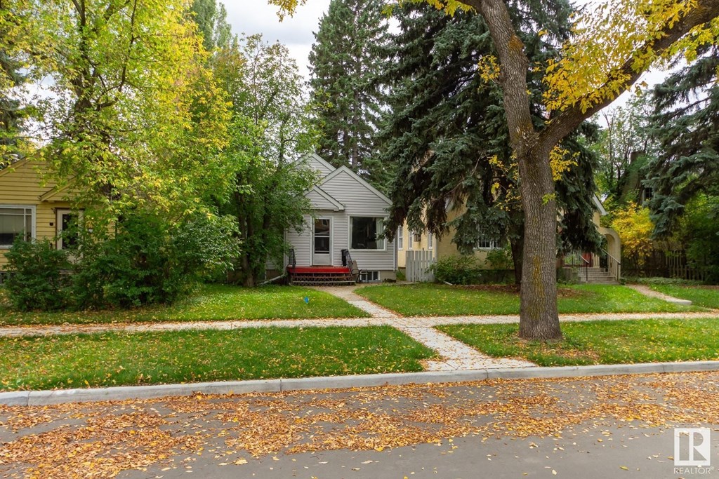 a white house with a red bench in the front yard