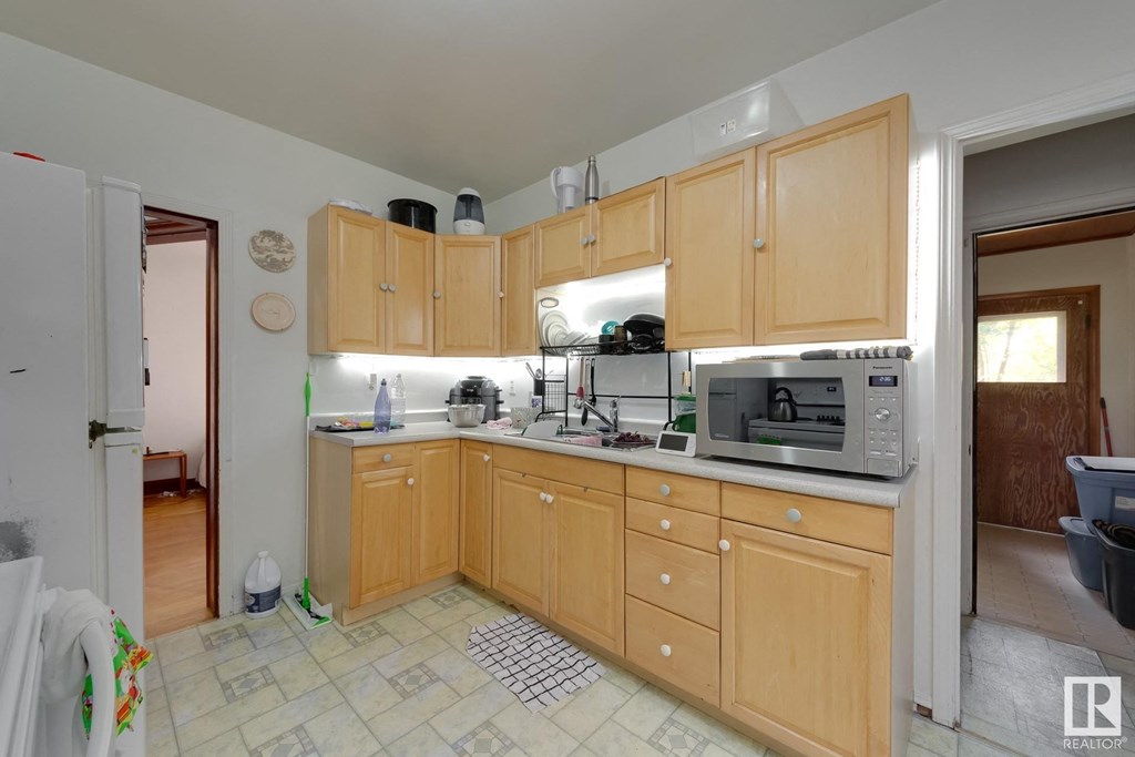 a kitchen with wooden cabinets and a sink and a microwave